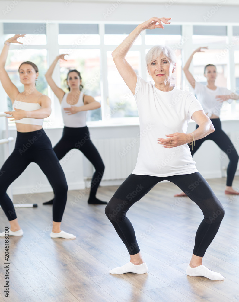 Obraz premium Graceful women of different ages practice various ballet movements in a choreographic studio