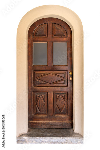 Vintage dark wood arched door, with geometric panels and glass windows, set in a cream-colored plaster archway, isolated