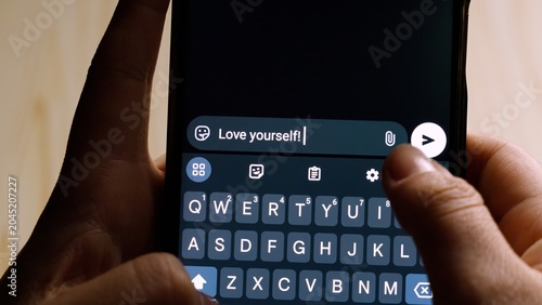 Close-up of hands holding a smartphone while typing 