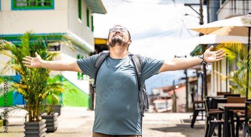 Happy male tourist with open arms on a street in Colombia