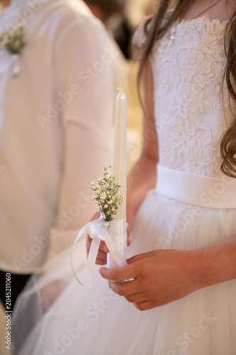 A girl holding a candle during first holy communion