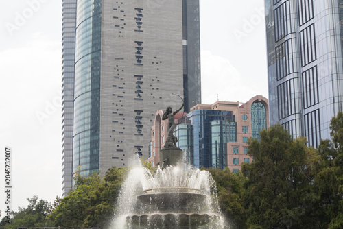 fountain of the hunting Diana in Reforma. Urban fountain surrounded by modern skyscrapers and green trees in Mexico City