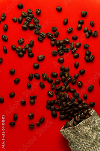 фотографія An aerial view of dark-roasted coffee beans spilling out of a rustic burlap sack