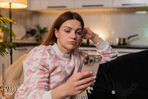 Fényképezés Middle-aged woman at night home browses smartphone news unhappy energy low feels burnout stress