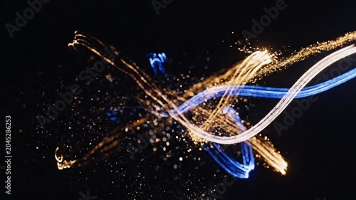 Abstract golden and blue light trails on black background
