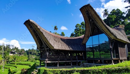 Traditional Toraja house with modern glass architecture extension.