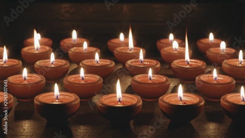 Traditional lit clay oil lamps glowing in the dark