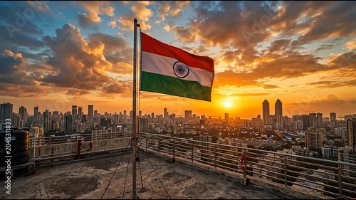 Indian flag on rooftop overlooking Mumbai city skyline sunset.