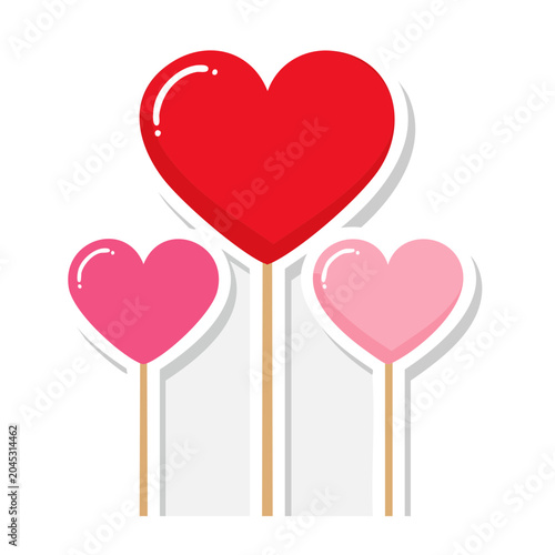 Three heart shapes on sticks, red and pink