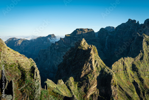 Принти на полотні Dramatic Mountain Landscape under Clear Blue Sky with Rugged Peaks and Valleys,