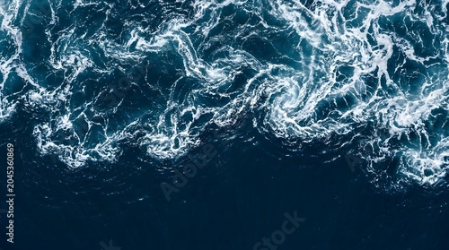 Waves crash on deep blue ocean surface in natural scenic view from above