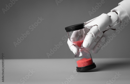 AI humanoid robot finger touching hourglass representing future and deadline.