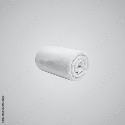 Rolled Up White Towel on Gray Background