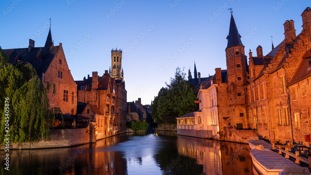 Fototapeta premium Bruges Canal at Dusk with Illuminated Buildings
