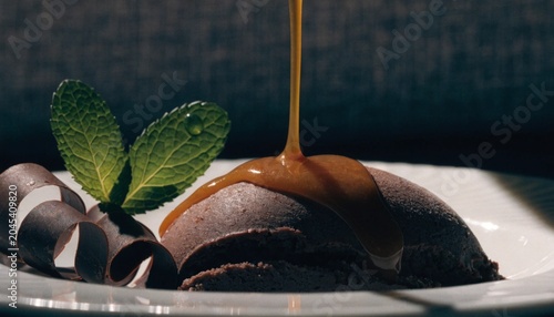 Chocolate dessert with sauce being poured on plate