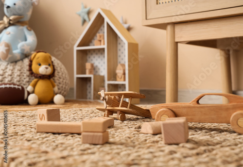 Wooden toys on rug in child...
