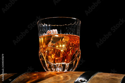Glass of cold whiskey on wo...