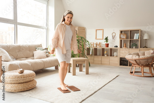 Young woman standing on Sadhu board at home