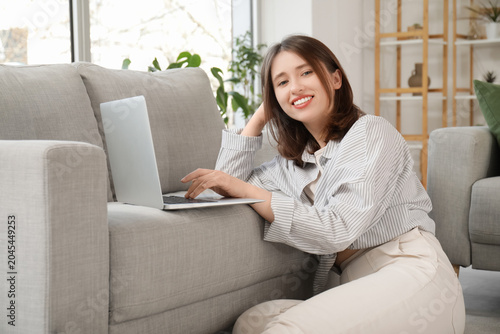 Happy young woman using lap...
