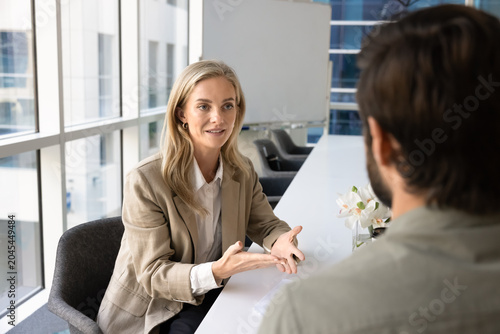 Φωτογραφία Young woman applicant answers questions during job interview sits at conference table in front of HR manager