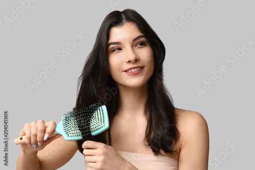 Pretty young woman brushing...