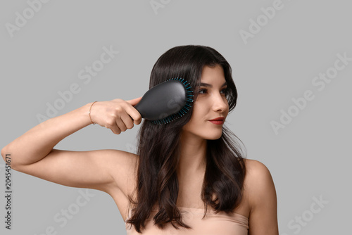 Pretty young woman brushing...