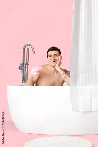 Young man in bathtub with l...