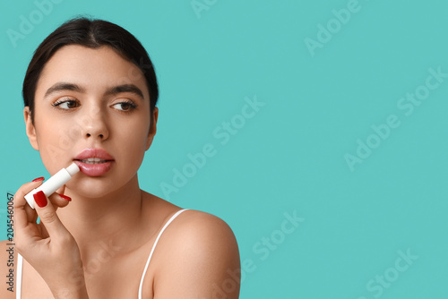Young woman applying lip ba...