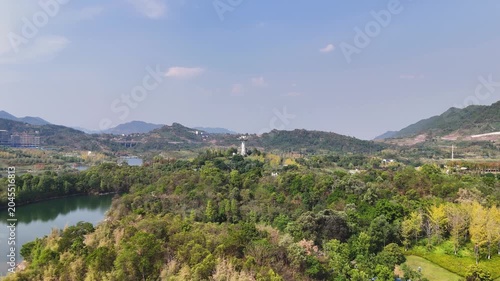 Aerial view of lakeside park and hills under blue sky