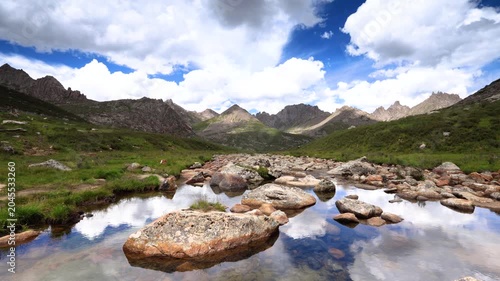 Rocky Mountain Stream with Reflections Under Dramatic Clouds