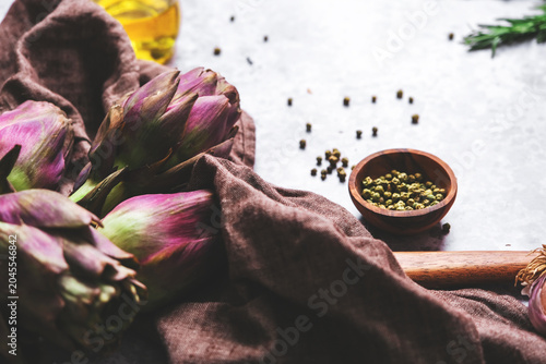 Canvas Print Artichokes on rustic linen napkin with peppercorns and olive oil bottle