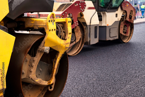 Φωτογραφία Heavy machinery operates to lay fresh asphalt on a city street