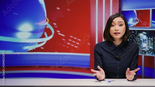 Obraz na płótnie Asian reporter covering news headlines in studio, talking about important daily events on live broadcast with breaking news report