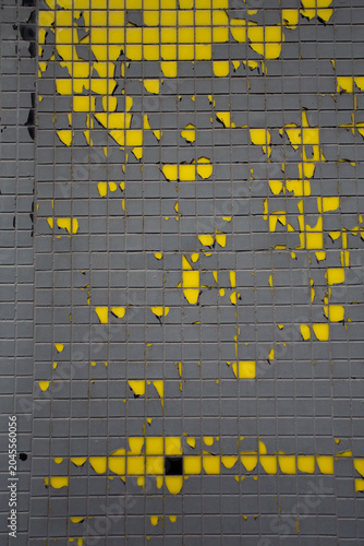 фотографія Carrelage émaillé jaune peint en gris avec peinture qui se décolle