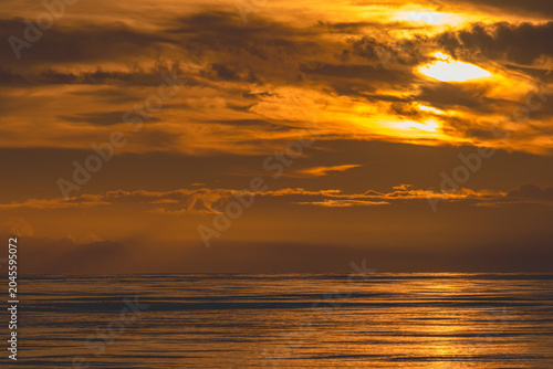 Foto Dramatic Orange Twilight Sky Over Sea and Mountain Silhouettes
