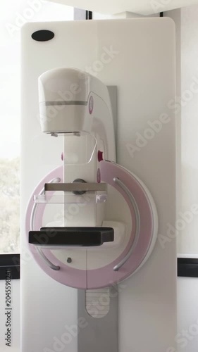 Vertical video: Camera recording imaging unit staying still in clinic for demo, showing pink gantry