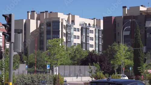 Modern residential apartment buildings with urban trees and street infrastructure on a sunny day in Madrid, Spain.