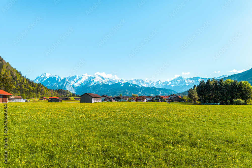 Fototapeta premium Bavarian village with forest and snowy peaks