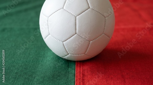 White Soccer Ball on Green and Red Fabric Background Representing Portugal