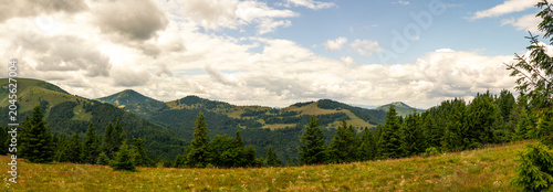 Schilderij op canvas Panoramic mountain landscape with rolling green hills, coniferous forests and dr