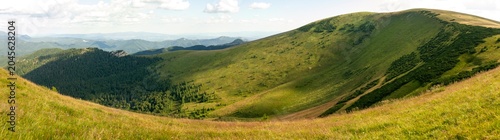 Foto Expansive panoramic view showcases green mountainous ridge covered with grass an