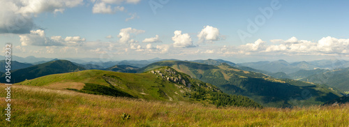 Картината върху платно Endless green ridges, wildflower meadows and craggy outcrops stretching beneath