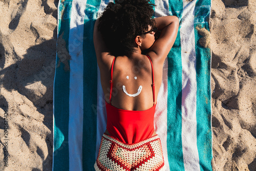 Canvas-taulu Woman enjoying summer vacation protecting skin with sunscreen