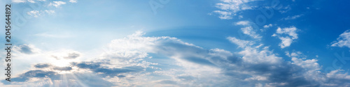 Wide angle panorama of beautiful sky with cumulus clouds over a clear horizon.