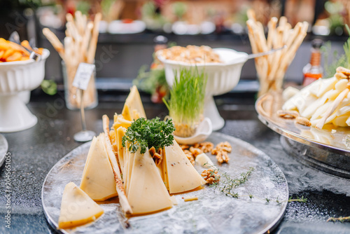 Bild auf Leinwand Assorted cheese platter featuring triangular cheese pieces garnished with herbs,