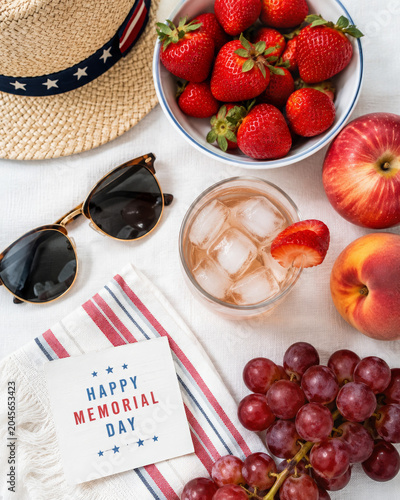 Bright summer flat lay featuring fresh fruits, sunglasses, hat and refreshing drink on light background, vacation lifestyle concept