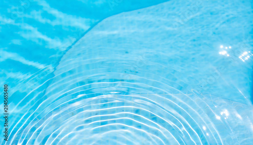 Ripples form on the surface of a serene blue body of water with gentle movement