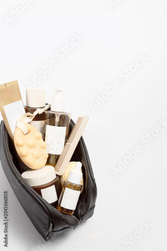 Aesthetic collection of cleanser products packed for travel included r oil pump bottle, foam tube crem jar,solid shampoo, toner bottle, sea sponge, minimal travel routine