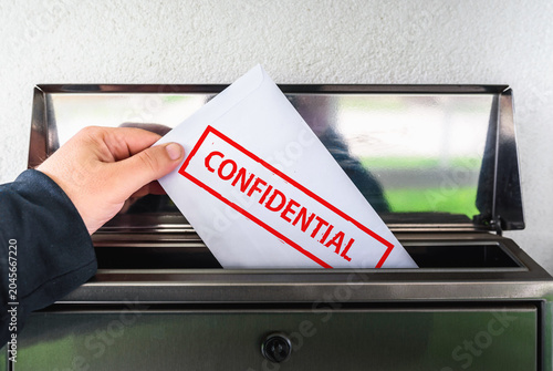 Hand Placing Confidential Envelope into Mailbox