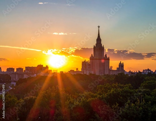 University skyscraper, tree line, and city. Sun rays. Golden hour. Beautiful